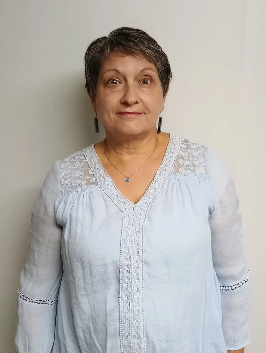 Sandy Wells smiling, wearing a light blue blouse